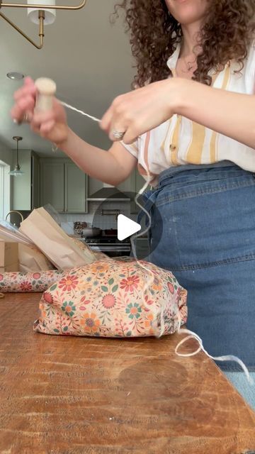 Sarah on Instagram: "Mother’s Day loaf wrapping, but make it floral!   Wearing my @ballerinafarm apron! Love it so much 🤎  #microbakery #sourdoughmicrobakery #organicmicrobakery #homestead #sustainable #sourdough #organicbread #organicgoods #bread #ovenspring #shaping #organicsourdough #baguette #organicbaguette #shaping #breadshaping #farmhouse #farm #homestead #ovenspring #puttingthebreadtobed #slowliving #bakeryviews #slowdown  #mothersday #gifting" How To Wrap Bread As A Gift Basket Ideas, Artisan Bread Wrapping Ideas, Apron Gift Wrapping Ideas, Packaging Bread Loaf, How To Gift Homemade Bread, Loaf Wrapping Ideas, How To Wrap Bread Loaf, Bread Gift Wrapping Ideas, Gift Wrap Sourdough Bread