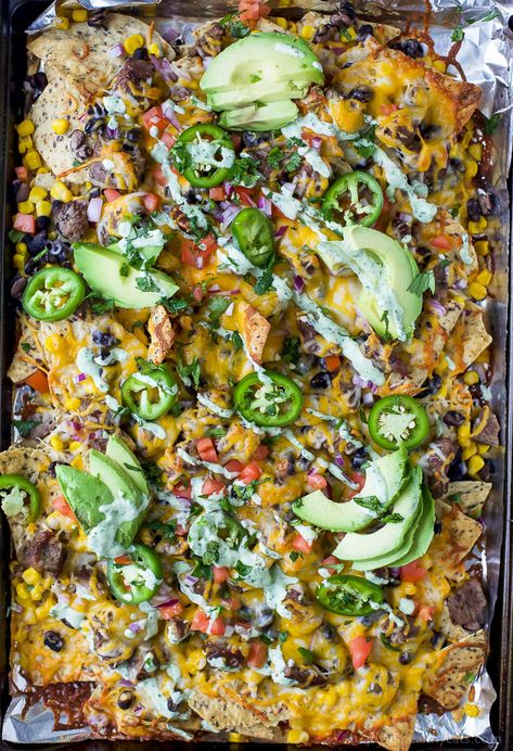 The Ultimate Cheesy Sheet Pan Steak Nachos Loaded Nachos Recipe, Steak Veggies, Best Nacho Recipe, Cilantro Lime Crema, Sheet Pan Steak, Steak Nachos, Nachos Recipe Beef, Gluten Free Recipes Appetizers, Baked Garlic Parmesan Chicken