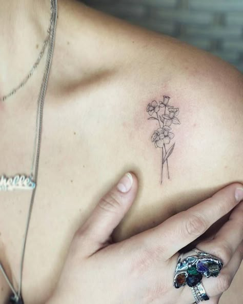 Fine line style daffodils tattoo done on the shoulder. Fine Line Flower Tattoo Daffodil, Minimal Daffodil Tattoo, Daffodil Back Tattoo, Daffodil Tattoo Fine Line, Daphadil Tattoo, Line Daffodil Tattoo, Rose And Daffodil Tattoo, Fine Line Daffodil, Fine Line Daffodil Tattoo