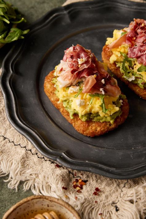 Introducing my Hashbrown Avocado Toast with Prosciutto—a delicious and satisfying breakfast or brunch option. This dish combines crispy hashbrowns, creamy avocado, prosciutto, arugula, and crumbled feta, all perfectly complemented by a drizzle of honey Eggs And Prosciutto Breakfast, Breakfast Prosciutto Recipes, Brunch Items Easy, Avocado Toast On Hashbrown, Hashbrown Skillet Breakfast, Brunch Hashbrown Ideas, Hash Brown Toast, Elevated Breakfast Ideas, Comfort Food Breakfast