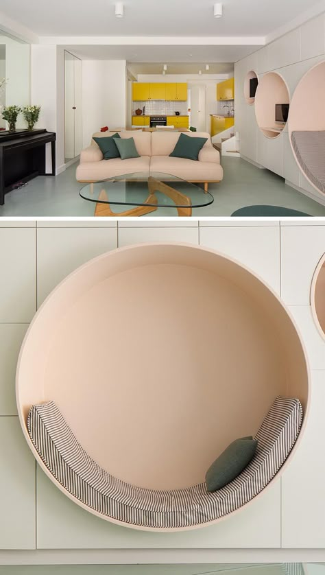 This modern living room has a wall of minimalist white cabinetry with multiple circular niches designed with different uses in mind. The largest circle has been defined as a reading nook, with an upholstered cushion that lines the bottom half of the shape, while the others have shelving for a computer and speakers. #ReadingNook #SeatingNiche #InteriorDesign French Apartment, Minimalist White, Bilik Tidur, 아파트 인테리어, White Cabinetry, Two Bedroom Apartments, Kids Interior, Niche Design, Kids Room Design