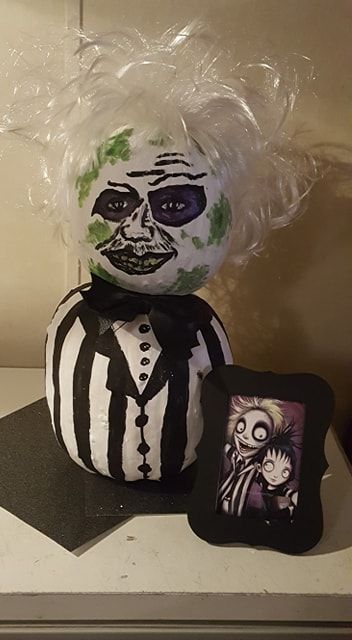 I decided to go with Beetlejuice for the Pumpkin contest at work (used: 2 white pumpkins, black, white, purple, yellow and lime green paint on the pumpkin. Used a cheap white costume wig for hair -cut, teased, sprayed with rave to make it stiff. Used a cheap faux leather hair-bow glued on an alligator clip. Most of the items I found at Michael's on the 70 % off isle). I won 1st place. So glad I decided to do this one! I looked thru cartoon images of him for the inspiration for his face. Beetlejuice Pumpkin Painting Ideas, Beetle Juice Pumpkin Painting, Beetlejuice Pumpkin Painting, Beetle Juice Pumpkin, Beetlejuice Pumpkin Carving, Halloween Pumpkin Contest, Beetlejuice Pumpkin, Lime Green Paint, Halloween Wine Bottle Crafts