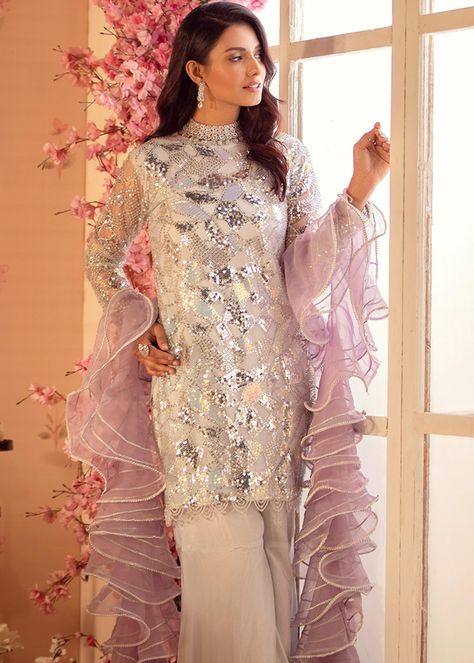 Include: Shirt: Length 36 Pant: 42 Dupatta Fabric: Shirt: Net Pant: cotton silk Dupatta : Organza Color: SilverWork Technique: Embellished, Embroidered, Adda Work Description: Luxury Net Shirt embellished with Resham Embroidery, Sequin and Cutdana with button details on back paired up with peplum Gharara pants styled with contrast color Ruffled dopatta which is adorned with charma dori. Length of this article is 36 inches for shirt and 42 inches for gharara. Model is wearing size Small and her h Peplum Gharara, Gharara Pakistani, Embroidery Tassels, Gharara Pants, Cutdana Embroidery, Net Shirt, Resham Embroidery, Simple Pakistani Dresses, Party Wear Indian Dresses