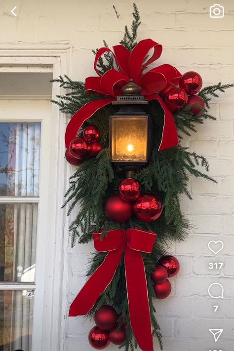 Red Front Door Christmas Decorations, Hanging Ornaments On Porch, Red Christmas Porch Decor, Red And White Christmas Swag, Xmas Front Porch Ideas, Outdoor Xmas Decorations Front Yards, Red And White Christmas Lights, Lantern Wreath, Outside Christmas Decorations