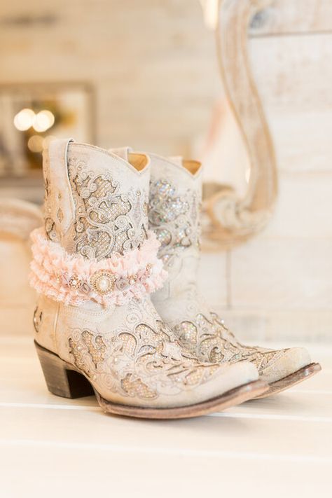 Bridal cowboy boots for barn wedding and sparkly pink lace garter Cowgirl Wedding Boots Brides, Farm Wedding Shoes Bride, White Cowboy Boots For Wedding, Bride Boots Wedding, Bridal Boots Cowboy, White Wedding Boots For Bride, Western Pink Wedding, Bridal Cowgirl Boots, Wedding Booties For Bride