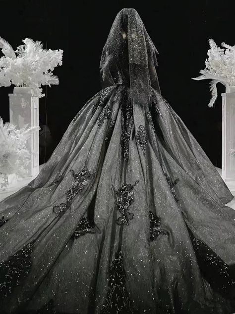 Our Majestic Twilight gown offers a breathtaking fusion of gothic charm and bridal elegance, tailor-made for the plus size bride who covets a unique and opulent look for her wedding day. The dress features a sumptuous silver lace overlay, meticulously adorned with intricate beading and sequins, creating a mesmerizing effect that sparkles with every movement. The bodice, with its refined structure and deep V-neckline, is both flattering and dramatic, leading to delicate cap sleeves that drape ove Black Glittery Wedding Dress, Black And Silver Wedding Dress, Tim Burton Wedding Dress, Gothic Wedding Dress Black And White, Majestic Wedding Dresses, Romantic Goth Wedding Dress, Grey Wedding Dress Silver, Space Wedding Dress, Dark Fantasy Wedding Dress