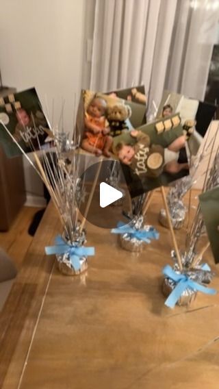 Meghan on Instagram: "Attempting to be a Pinterest mom with these centerpieces for my son’s first birthday!   Everything I used was mostly from the dollar tree.   - balloon weights  - 4x4 pictures  - skewers  - tape  - white cardstock - ribbon  These weren’t difficult to make at all and were so much cheaper than getting flowers. I was pleasantly surprised with how they turned out! 🩵#dollartree #firstbirthday #firstbirthdaydecor #diy #crafts #centerpieces #boymom #monthlymilestones #pinterestmom" Dollar Tree First Birthday, Balloon Weights Diy Centerpieces, Picture Centerpiece Ideas Birthday, Photo Centerpieces Diy Birthday, Diy Centerpieces For Party Birthdays, 1st Birthday Centerpiece Ideas, First Birthday Table Centerpieces, Dollar Tree Centerpieces Birthday, Diy Birthday Centerpieces