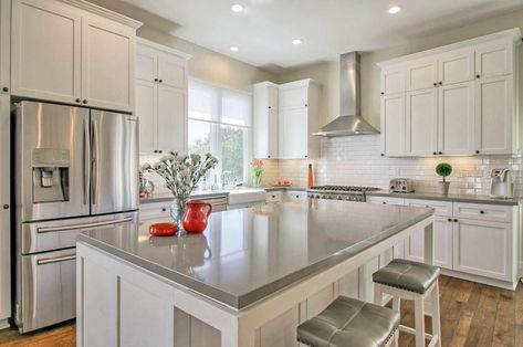 Kitchen with white cabinets and gray quartz countertops white tile backsplash and wood flooring White Cabinets Grey Countertops, Countertops With White Cabinets, Types Of Kitchen Countertops, Gray Countertops, Gray Quartz Countertops, Kitchen Countertop Ideas, Backsplash For White Cabinets, White Cabinets White Countertops, Small White Kitchens