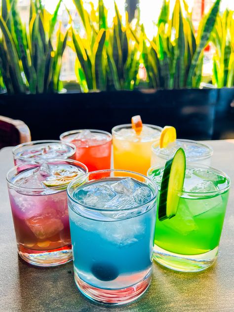 Rainbow drinks on a table. Rainbow Cocktail Party, Drink The Rainbow Mexico, Colour Cocktail Party, Rainbow Dinner Party, Coloured Cocktails, Rainbow Cocktails, Rainbow Bachelorette Party, Pride Cocktails, Rainbow Bachelorette