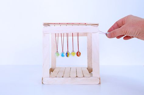 Learn how to make a simple Newton's Cradle, the classic science project demonstrating momentum! Classroom Experiments, 8th Grade Science Projects, Popsicle Stick Picture Frame, Babble Dabble Do, Shape Matching Game, Steam Lessons, Newton's Cradle, Unicorn Craft, Experiments Kids