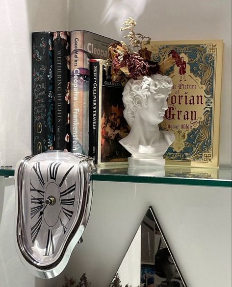 Bookshelf Hanging Wall, Book Holder Aesthetic, Bookshelf Decorative Objects, Book Decor Bedroom, Melting Clock Decor, Books On Desk Aesthetic, Book Display Ideas Bedroom, Bookshelf Inspo Bedroom, Weird Room Decor