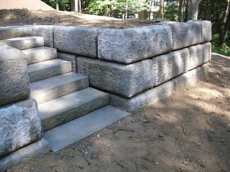 Here’s a gorgeous design using concrete blocks. Massive concrete blocks, that is. If you’re browsing through any cinder block retaining wall ideas, this one may be the design to stop at. The blocks are neutral grey, but huge and textured to add interesting character and depth to any garden space. The stone steps cut into the massive blocks looks almost like a fairy tale scene in the woods. This is a great idea for a summer getaway home or lodge in the mountains. Inexpensive Retaining Wall Ideas, Cinder Block Garden Wall, Cheap Retaining Wall, Concrete Block Retaining Wall, Block Retaining Wall, Natural Stone Retaining Wall, Retaining Wall Steps, Boulder Retaining Wall, Retaining Wall Ideas