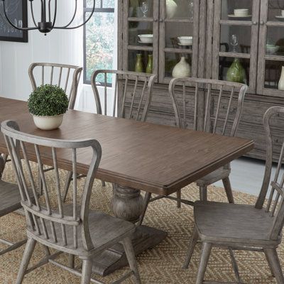 Built to instill a sense of calm and tranquility into your space, this Cogan dining set is just the right balance of cozy farmhouse and modern home. It includes an extendable table with rounded edges and a trestle base with heavy turned pedestals that reach bracket feet and a horizontal beam in between. The chairs feature a Windsor design that shows off softly shaped wing backs, vertical slats, and eye-catching angled, tapered dowel legs. All pieces are crafted from solid and engineered wood wit Farm Dining Table, Farmhouse Dining Set, Modern Farmhouse Table, Extendable Table, Trestle Table, Cozy Farmhouse, Colorful Table, Laurel Foundry Modern Farmhouse, Farmhouse Table