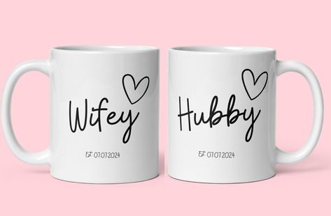 Welcome to our charming collection of Hubby and Wifey Personalised Mugs!  Celebrate your love and the special bond you share with these beautifully crafted ceramic mugs. These enchanting mugs feature a stylish design that showcases the endearing Hubby and Wifey titles, making them the perfect gift for newlyweds, anniversaries, or just to add a touch of romance to your mornings.  To make them truly unique, we offer personalisation options, allowing you to add wedding dates  to these delightful mugs.  Crafted with care and attention to detail, these mugs are not only visually appealing but also comfortable to hold and sip from. Start your day with a warm cup of love with our Hubby and Wifey Personalised Mugs! Thank you for stopping by at Kelham Treasures. Alice xoxo Engraving Designs, Bridal Shower Presents, Wedding Dates, Gift For Newlyweds, Personalised Mugs, Newlywed Gifts, Wedding Date, Bridal Shower Gifts, Godmother