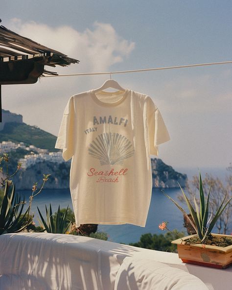 Found Amalfi’s best-kept secret ~ a vespa ride through Positano and a hidden cliff trail led us to a nameless beach, which I now call Seashell Beach 🐚🍋🐟 Beach Graphic Tee, Graphic Tee Outfit Aesthetic, Shell Tshirt, Seashell Graphic, Obx Outfits, Italy Pattern, Handpainted Tote, Beach Mood, Souvenir Shirt