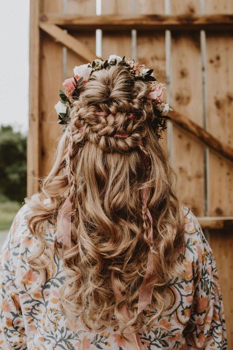 Medieval style hair look with braids and pink ribbon topped with a pink and white flower crown