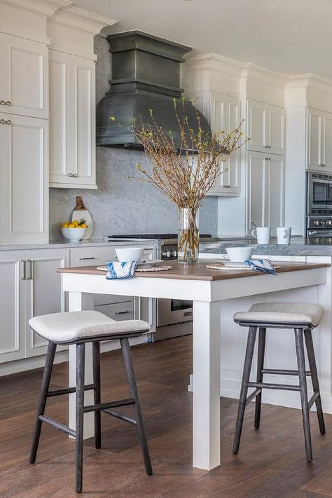 A white kitchen island is fitted with an extended dining table seating black oak counter stools at a wood countertop. Island As Dining Table, Kitchen Island As Dining Table, Extended Kitchen Island, Cobalt Blue Kitchen, White Marble Kitchen Island, Extended Kitchen, Blue Kitchen Island, Marble Kitchen Island, Florida Interior Design