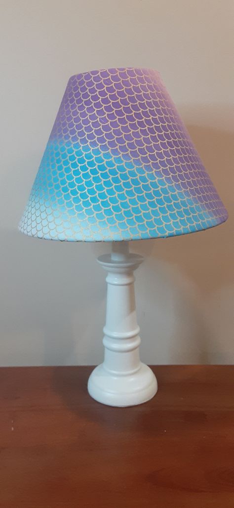 This vividly colored accent lamp features a fabric upholstered shade depicting mermaid scales in  lovely colors of turquoise, lavenders, and purples with a hint of pink. I chose to upholster this shade so that the front and back are slightly different, giving the buyer the option to choose which colors will be prominent on the front of the shade. The two side seams are finished off to give this lamp a lovely look.   The mermaid scales are outlined in gold glitter. The lamp stands 15 1/2 inches t Beach House Lamp, The Mermaid Scales, Little Mermaid Bedroom, Mermaid Themed Bedroom, Base Sitting, Mermaid Lamp, Nautical Lamps, Colorful Dresser, Mermaid Bedroom