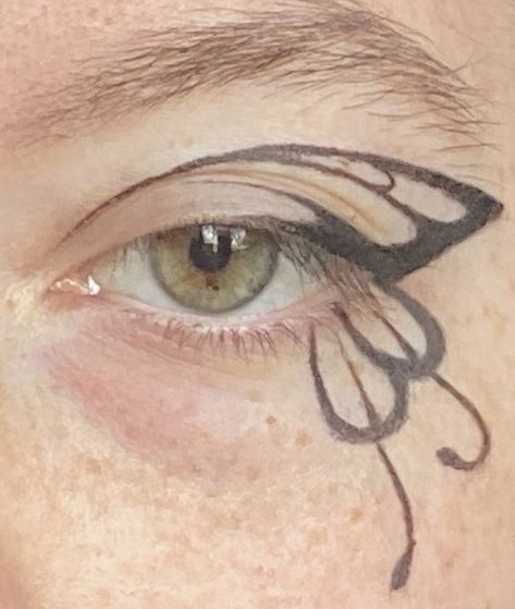 Black winged eyeliner that resembles a butterfly wing Graphic Eye Makeup Looks, Makeup With Graphic Eyeliner, White Butterfly Eyeliner, Butterfly Liner Makeup, Butterfly Wing Makeup, Easy Butterfly Eyeliner, Butterfly Graphic Liner, Graffiti Eyeliner, Fairy Wing Eyeliner