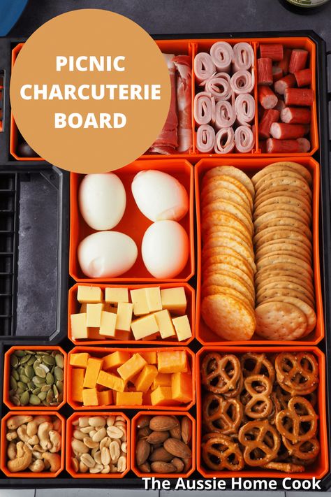 This picnic charcuterie board, or snackle box, makes the ultimate easy and fun portable food. Perfect for a picnic or a camping or fishing trip. Did someone say snack attack? River Float Lunch Ideas, Charcuterie Travel Board, Fishing Box Charcuterie, Fishing Tackle Box Snacks, Fishing Snack Ideas, Portable Charcuterie Board Ideas, Shackle Box Ideas For Kids, Lake Day Snack Ideas, Snackle Box Ideas For Boat