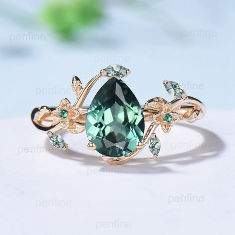 Elegant Pear Green Sapphire Ring Nature Inspired Teal Sapphire Engagement Ring Flower Green Agate Wedding Ring Emerald Branch Leaf Vine Ring ≫≫ Item Details  Make every ring to order, all rings are handmade in the United States.  Metal: Solid 10K & 14K & 18K Gold  Gold Color: Rose gold, Yellow gold, White gold ➽ Center Stone 6x8mm pear shaped  lab green sapphire ➽ Accent Stone:  2pcs lab emerald + 4 pcs natural moss agate Need a matching band? https://www.etsy.com/listing/1239338019/twig-branch- Luxury Green Rings As Gift, Luxury Green Solitaire Wedding And Engagement Ring, Unique Leaf Wedding Rings With Sapphire, Luxury Green Wedding And Engagement Ring With Accent Stones, Luxury Green Sapphire Ring For Women, Luxury Green Sapphire Ring, Cheap Green Wedding Rings, Green Flower Rings, Green Wedding Rings For Her