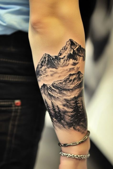 Forearm tattoo of realistic mountains and trees in black and grey ink. Mountain Sketch Tattoo, Montani Semper Liberi Tattoo, Big Mountain Tattoo, Snow Capped Mountain Tattoo, Scenery Tattoos For Men, Sierra Nevada Mountains Tattoo, Rock Tattoo Nature, Mountain Arm Tattoo, Mountain Tattoo Men