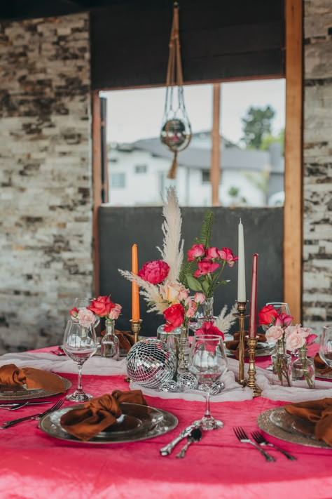 It was so fun to style this disco ball themed table! We used bright pink linens, pink flowers in assorted bud vases, vintage style candlestick holders, and of course disco balls! Gold chargers and clear plates completed the place settings along with brown napkins and antique silverware. Pink And Orange Disco Ball Wedding, Bridal Shower Pink Theme, Disco Reception, Brown Napkins, Themed Bridal Shower Ideas, Community Heroes, Cheesecloth Runner, Round Table Settings, Bridal Shower Pink