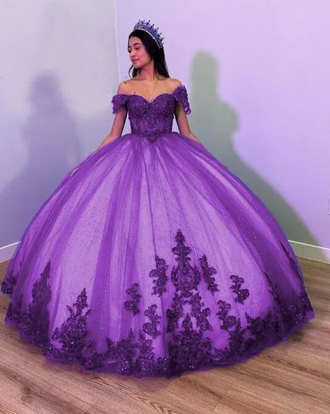 Step into your dream Quinceanera with the Fiora Ball Gown. This exquisite gown features a classic ball gown silhouette, beautifully crafted from layers of luxurious tulle fabric that add volume and movement to your every step. It is available in vibrant colors like royal blue, red, pink, purple, and green. The lace-up back ensures a perfect fit, accentuating your figure while adding a touch of classic charm. The intricate applique details and delicate beading sparkle with every turn, making you Dark Purple Quince Dresses, Dark Purple Quinceanera Dresses, Off The Shoulder Quinceanera Dress, Dream Quinceanera, Royal Purple Dress, Purple Quinceanera Dresses, Gown Silhouette, Quinceanera Themes Dresses, Purple Wedding Dress