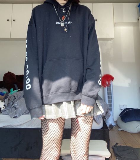 a female model wears an oversized black hoodie with the text “unus annus” written on it, with the number 00:00:00 on one arm and 365:00:00 on the other arm. she wears a white and brown plaid skirt with pleats, with black fishnet tights underneath. she wears several chunky chain necklaces over the hoodie, as well as a black diamanté studded choker Baggy Clothes With Skirt, Hoodie Skirt Outfits Korean, Edgy Hoodie Outfit, Hoodie And Skirt Outfit Korean, Big Hoodie And Skirt Outfit, Oversized Hoodie Skirt Outfits, Oversized Hoodie Outfit Summer, Big Hoodie Outfit Aesthetic, Skirt Fishnets Outfit