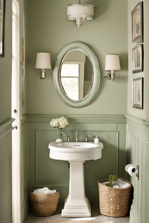 Elegant bathroom featuring a pedestal sink, an oval mirror, and soft green walls with wainscoting. Powder Room Narrow, New England Powder Room, Powder Room Update On A Budget, Bold Powder Room Ideas, French Powder Room, Small Powder Room Design, Bold Powder Room, Blue Powder Room, Vintage Powder Room