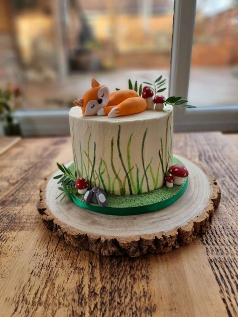 Birthday cake, painted grass with sleeping fox and toadstools, bunny and leaves. Green and white. Buttercream. Rustic woodland themed 1st Birthday Cake Woodland, Woodland Creature Birthday Cake, Diy Woodland Cake, Fox First Birthday Cake, First Birthday Cake Woodland, Woodland Animals Birthday Cake, Woodland Creature Smash Cake, Fox One Year Old Birthday, Woodland Fox Cake