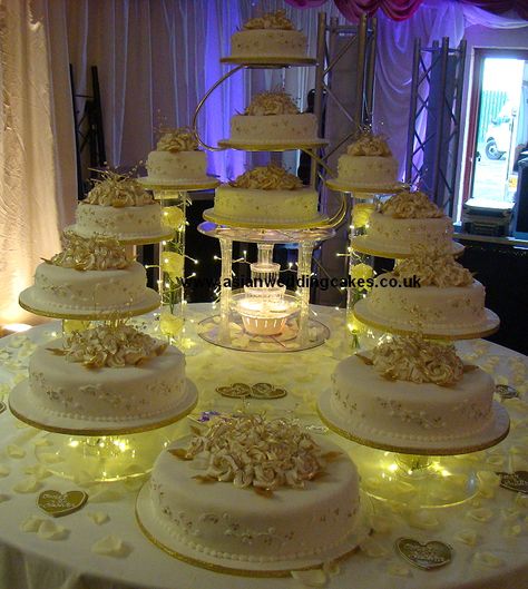 Big Wedding Cakes with Fountains | The cake is decorated with White roses with a classic gold edging. The ... Cakes With Fountains, Fountain Wedding Cakes, Hanging Cake, Quince Cakes, Quince Cake, Fountain Cake, Big Wedding Cakes, Quinceanera Cakes, Wedding Cake Roses