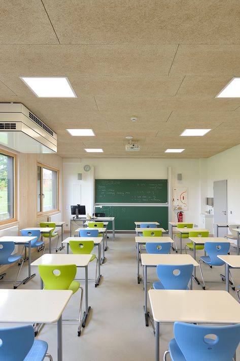 A new, modern, open-plan building frames this German secondary school. The interior design creates a welcoming atmosphere, consisting of wide hallways and wooden element. Troldtekt acoustic panels on walls and ceilings ensure a healthy indoor environment with superior acoustics. #goodacoustics #holzwolleplatten #träullsplattor #troldtekt School Building Design Interiors, Classroom High School Design, Modern School Building Design, Modern School Interior, Modern Classroom Design, Panels On Walls, School Classroom Interior, Innovative School Design, Wide Hallways