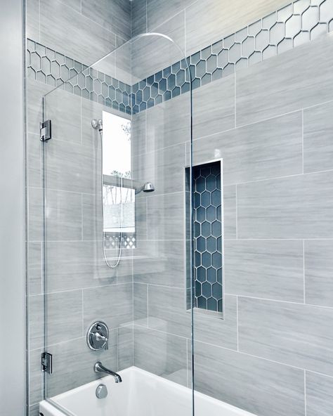 A gorgeous pop of blue really shines in this beautiful, spa-like shower. #showerdesign #showers #showertile #bathrooms #bathdesign #interiordesign #bathrooms #shower #interiors Master Shower Rain Head, Bathroom Shower Tiles Gray, Small Shower Tub Ideas, Bathroom Blue Shower Tile, Walk In Shower With Blue Accent Tile, Large Blue Shower Tile, Blue Glass Tile Bathroom Showers, Blue Bathroom Tiles Shower Ideas, Nautical Tile Bathroom