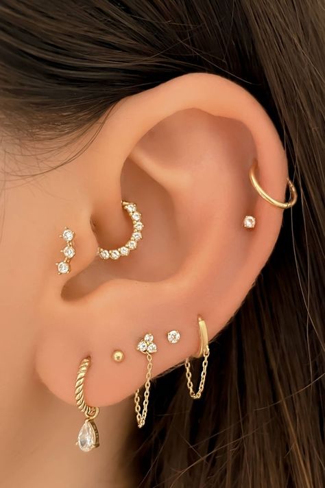 If your ears have been feeling a little bare lately, Assolari's cute ear piercings will convince you to get your cartilage piercings RN! If you’ve scrolled through IG or Pinterest in the last year, you’re well aware that ear piercings are very much a thing right now. A carefully and beautifully curated ear is THE way to show your personal style. Ear Peicerings Ideas, Ear Piercings Placement Chart Classy, Ear Constellation Piercings, Unique Ear Piercings Classy, Eat Piercings Chart, Ear Design Piercing, Multiple Ear Piercings Aesthetic, Styled Ear Piercings, Eat Piercings