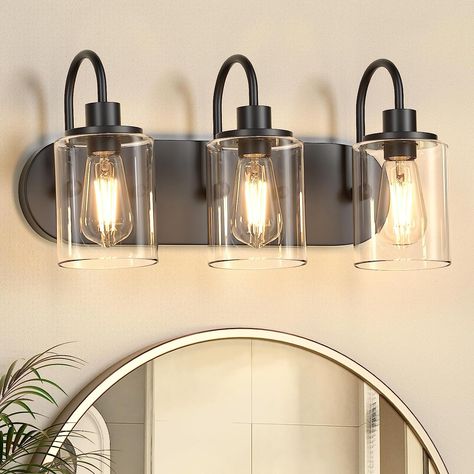 This 3-Light black bathroom light fixture is the perfect addition to any modern or farmhouse home decoration! Unlike other traditional design, this bathroom sconce wall lighting features an oval shaped backplate design. Crafted from durable matte black lamp body with clear glass shades, they are ideal for adding a touch of style to your bathroom mirror, bedroom, living room, or dressing table. Good choices for home decoration! #ad #amazon #farmhouse #bathroomdecor #lightfixture Matte Black Bathroom Vanity Light, Matte Black Bathroom Light Fixtures, Bathroom Vanity Lighting Over Mirror Black, Black Bathroom Light Fixture Over Mirror, Black Vanity Lights Bathroom, Bathroom Light Fixtures Black, Black Vanity Lights, Black Bathroom Light Fixtures, Bathroom Amazon