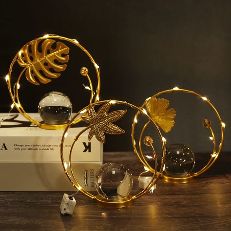 PRICES MAY VARY. Decorative Crystal Ball Set - Three gold decorations create an elegant charm. The translucent crystal balls with metal leaf sculptures are the good addition to your home decor and add a gorgeous touch and romantic ambiance to any space. Exquisite Craft & Light Strips Accessory - These unique home decor ornaments feature three leaves sculptural design with exquisite craft, all of which measure 5.3 x 5.3 inches. Comes with three 20 inch lengths of light strips that can be wrapped Non Floral Table Decor, Glam Mantle Decor, Table Fireplace, Living Room Dining Table, Gold Decorations, Romantic Ambiance, Dining Table In Living Room, Nightstand Decor, Metal Art Decor