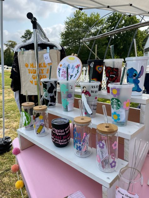 The perfect white tierd cup display! Summer craft fair display! #starbucks #craftfair #craftfairdisplay #aesthetic #smallbusiness #market #tumbler #glassware #shop #shopsmall #shopsmallbiz #totebagpattern #harrystyles #disneyinspired Grid Wall Craft Booth, Cup Vendor Display Ideas, Tumbler Stand For Craft Show, Craft Fair Cup Display, Cup Vendor Display, Tumbler Market Display, Display Stands For Craft Shows, Cup Display Ideas Craft Fairs, Tumbler Display Ideas