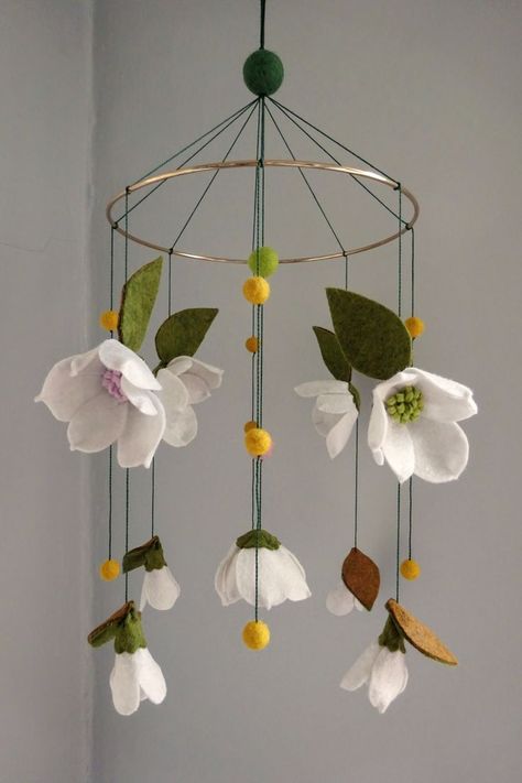 Bring a touch of southern elegance to your baby's nursery! Little eyes will be mesmerized watching the magnolia blossoms spin through the air. This mobile has five open magnolia blossoms, one with a yellow center, two with a pink center, and two with a green center. There are four buds with pink or green centers, and don't forget the iconic green and brown leaves! Handmade from felt, this mobile will be a treasured heirloom. Magnolia Nursery Decor, Magnolia Nursery, Southern Nursery, Southern Baby, Southern Elegance, Yellow Nursery, Flower Mobile, Magnolia Baby, Brown Leaves