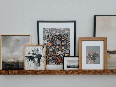 How to Style a Picture Ledge – Love & Renovations Frames On Shelf Display, Photo Shelf Styling, Gallery Wall On Shelf, Picture Shelf Over Sofa, Styling Picture Ledges Living Room, Eclectic Picture Ledge, Shelves With Large Pictures, Long Ledge Shelf, Ledge Photo Wall