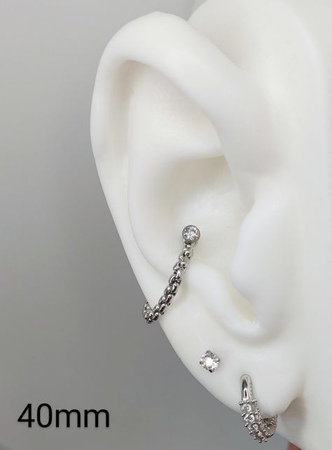 "Have you wanted something that may give the impression of a hoop, but your ear is sensitive to the curve of a hoop? A chain might be a better fit!! These chains are 2mm wide, and made of rounded stainless steel links. These are sold chain only and per Single piece. When choosing a Labret to wear with the chain, I recommend using a \"Threadless\" or \"push in\" labret. These are much more user friendly when trying to secure the jewelry head in the post while holding the chain in place. Prior to Conch Earring Silver, Conch Piercing Chain Jewelry, Conch Jewelry Silver, Conch Earring Hoop, Conch With Chain, Chain Conch Piercing, Conch Chain Earring, Conch Piercing Chain, Conch Chain