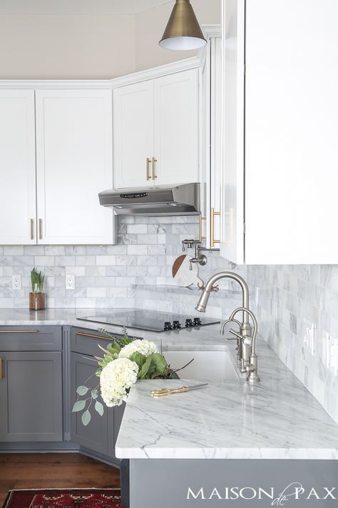 Two-toned gray and white cabinets, marble subway tile, Carrara countertops, a big farmhouse sink, and brass hardware give this kitchen a classic yet modern look. Gray And White Cabinets, Big Farmhouse, Marble Subway Tile, White Marble Kitchen, С�ерая Кухня, Gray And White Kitchen, Kabinet Dapur, Marble Kitchen, Farmhouse Kitchen Cabinets