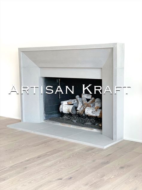 Modern beveled fireplace surround made from cast stone that is meant to resemble real limestone. Hardwood flooring with a hearth and cast mantel surround. Contemporary Fireplace Surround, Picture Frame Fireplace Surround, Beveled Fireplace Surround, Plaster Fireplace Surround, Raised Fireplace, Modern Fireplace Mantels, Limestone Fireplace Surround, Cast Stone Mantel, Cast Stone Fireplace