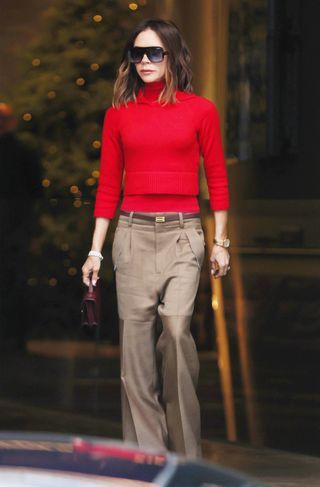 Victoria Beckham red and tan outfit Red And Camel Outfit, Red Sweater Outfit Winter, Camel Outfits, Oversized Black Sunglasses, Camel Outfit, Tan Outfit, Red Turtleneck Sweater, Red Turtleneck, Style Muse