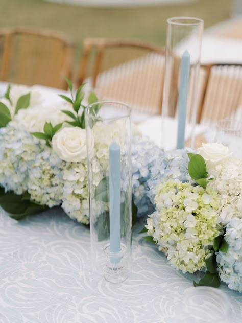 a blue patterned linen with a hydrangea table runner in blue and white with light blue candlesticks White And Blue Wedding Centerpieces, Blue Candles Wedding, Blue Hydrangea Arrangements, Hydrangea Table Arrangements, Hydrangea Runner, Hydrangea Wedding Table, Hydrangea Table Runner, Wedding Flowers Blue Hydrangea, White And Blue Hydrangea