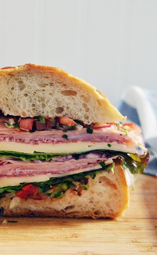 ► Muffuletta Sandwich Recipe: Italian or French bread loaves, soppresata, mortadella, provolone, ham, red leaf lettuce, red onion, white vinegar, sugar, tomatoes, yellow onion, mixed sliced olives, celery, hot peppers (jalapenos), flat leaf parsley, marinated sweet cherry peppers, olive oil, red wine vinegar, garlic, oregano, fresh basil, salt and pepper. Super Bowl Sandwiches, Muffuletta Recipe, Muffaletta Sandwich, Muffuletta Sandwich, Italian Sandwich, Party Sandwiches, Tomato Relish, Sub Sandwiches, Super Bowl Party