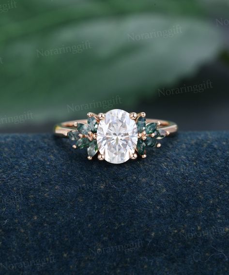 "Oval shaped Moissanite engagement ring Unique rose gold engagement ring Marquise cut Moss agate Cluster ring Bridal dainty Anniversary ring -----Ring Information----- +Center stone: 6*8mm Moissanite +Color: DEF +Clarity: VS-VVS +Cut type: Oval shaped +Side Stone:  Moss Agate Approx weight: 0.4ctw Metal : Solid 14k/18k yellow gold white gold or rose gold, other metal or gemstones, please contact me! Click on the \"Pin It\" icon if you like this item, Thanks so much! Ring Size All rings are stand Unique Engagement Rings Without Diamonds, Simple Rustic Engagement Rings, Diamond And Emerald Engagement Ring Gold, Color Moissanite Engagement Ring, Gold Engagement Ring With Emerald, Wedding Ring Ethereal, Emerald And Moissanite Ring, Moss Agate Oval Engagement Ring, Engagement Rings With Green Accents