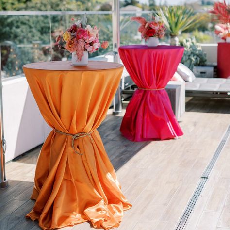 Complete the look of your special day with our Satin Tablecloths! Our Satin Tablecloths are the epitome of class and elegance for any sophisticated event. Satin has a gorgeous sheen surface that beautifully reflects light to show off the unique folds and draping, creating a truly unique romantic atmosphere. Best of all, satin is a versatile fabric that can be paired with any other solid or textured fabric and still maintain a cohesive look at your wedding or event! Coordinate with our large sele Pink Orange White Wedding, Decorating Round Tables For A Party, Lounge Birthday Party Decor, Summer Event Decor, Monochromatic Party Decor, Coachella Bridal Shower Theme, Sweet 16 Orange Theme, Colorful Backyard Party, Fundraising Event Decor