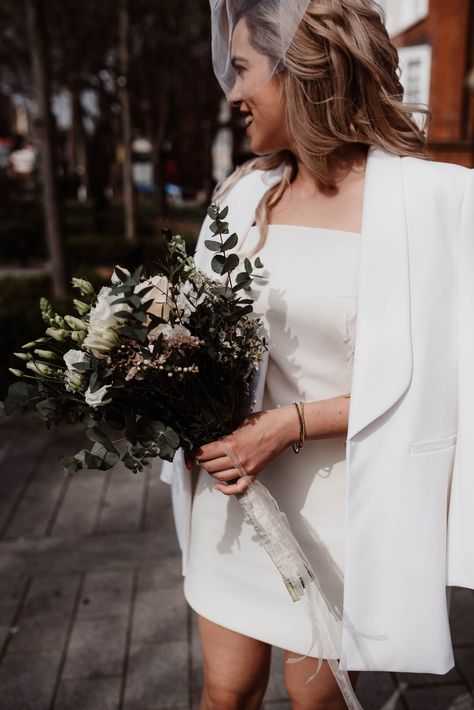 Bride in White Blazer & Short Wedding Dress and Birdcage Veil with White Flower and Foliage Bouquet City Hall Wedding Dress, Foliage Bouquet, Town Hall Wedding, Short Bridal Dress, Boda Ideas, Civil Wedding Dresses, Beige Wedding, Bridal Jacket, Wedding Court