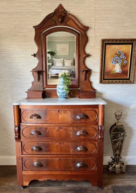 "Dimensions: 38\" wide x 18.5\" deep x 38\" tall (without mirror) Mirror: 44\" tall Overall height with mirror: 82\" tall Description: Immerse yourself in the rich heritage of the Victorian era with this exceptional Eastlake dresser, a true testament to the opulence and fine craftsmanship treasured by the middle to upper-middle class of its time. Embellished with exquisite flame mahogany drawers and adorned with a lavish Italian white marble top, elegantly veined with graceful gray patterns, this piece epitomizes sophistication and timeless charm. The marble, delicately beveled and discreetly marked with a carved letter 'R' underneath, exudes an aura of historical allure. Noteworthy is the unique swivel mirror, gracefully aging with subtle silvering, boasting a distinctive shape and mechan Eastlake Dresser, Antique Dresser With Mirror, Eastlake Furniture, Victorian Dresser, Marble Top Dresser, Eastlake Victorian, Swivel Mirror, Beautiful Antiques, Candle Shelf